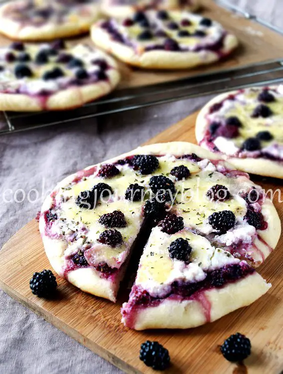 blackberry pizza with blackberries on a board