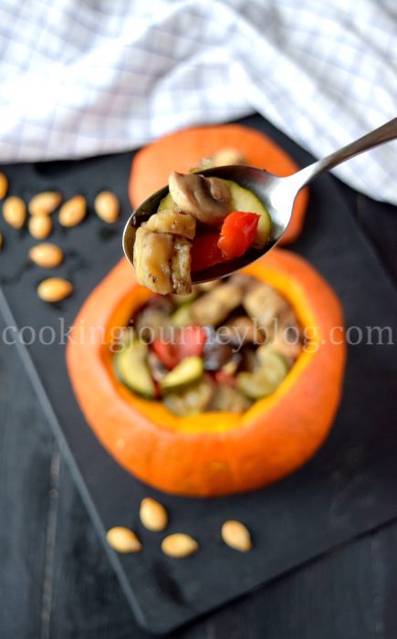Stuffed pumpkin with baked vegetables is beautiful and healthy meal. Spoon with baked vegetables