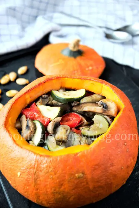 Stuffed pumpkin with baked vegetables is beautiful and healthy meal. Orange pumpkin, stuffed with zucchini, eggplant, mushrooms and bell pepper.