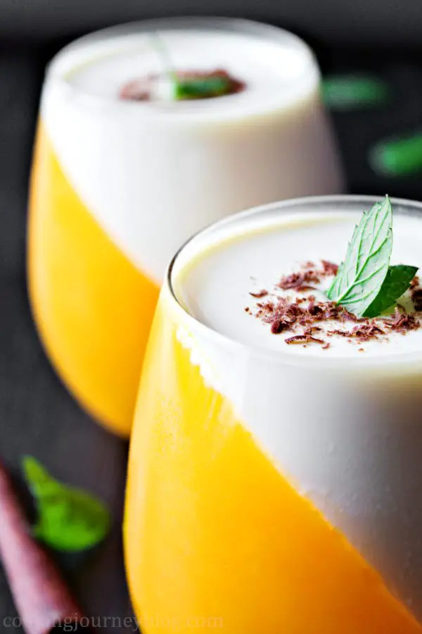 Orange panna cotta is creamy and fresh dessert, one of the Christmas dessert ideas you can make for your family. Easy no bake desserts that you will enjoy! Orange and white dessert, served with peppermint leaves and shredded chocolate.