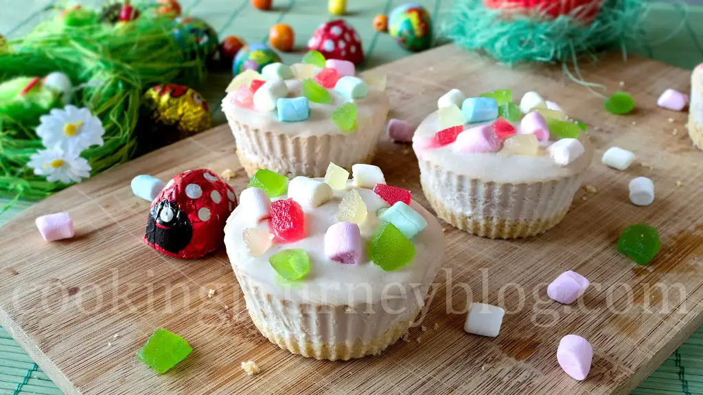 Mini cheesecake with colorful marshmallows served on a wooden board