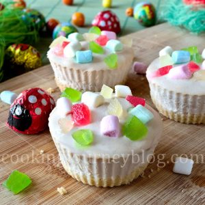 Mini cheesecake with colorful marshmallows served on a wooden board