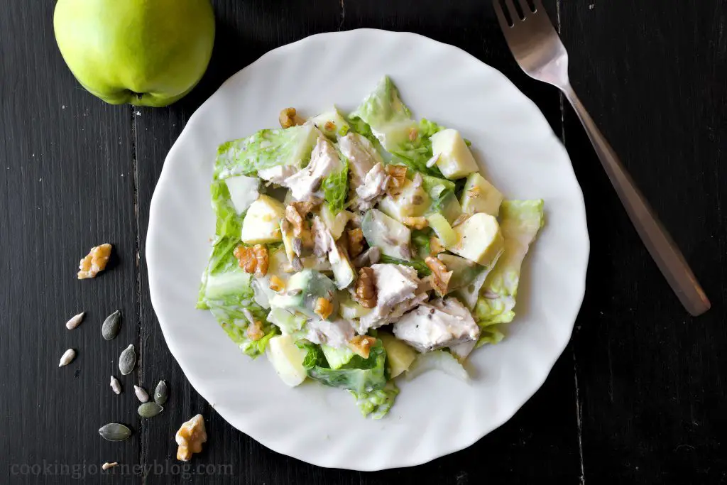 Avocado chicken salad, apples on the background