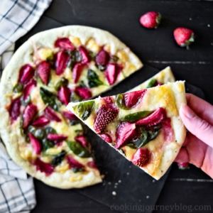 Mozzarella strawberry pizza slice in hand