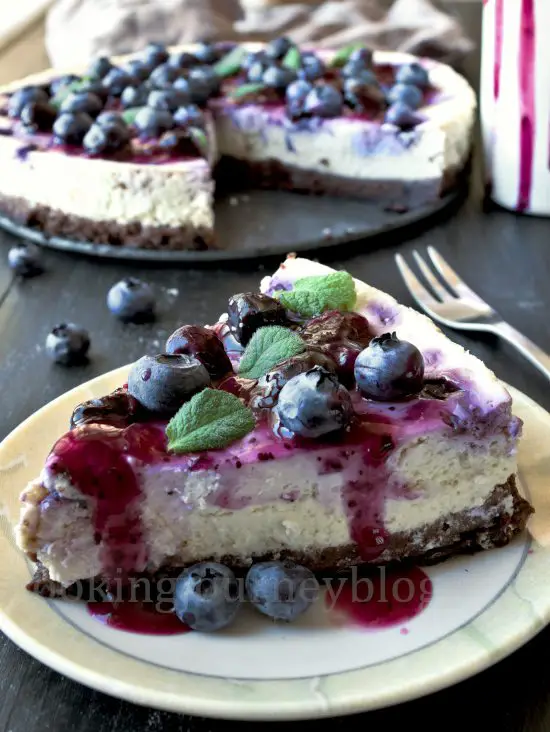 Blueberry cheesecake slice on the plate with blueberry sauce