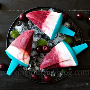 Homemade sugar free popsicles, served with ice, mint and cherries for three persons, view from top