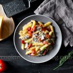 Creamy Mushroom Pasta with Tomatoes, cheese and dill, served on gray plate on black table