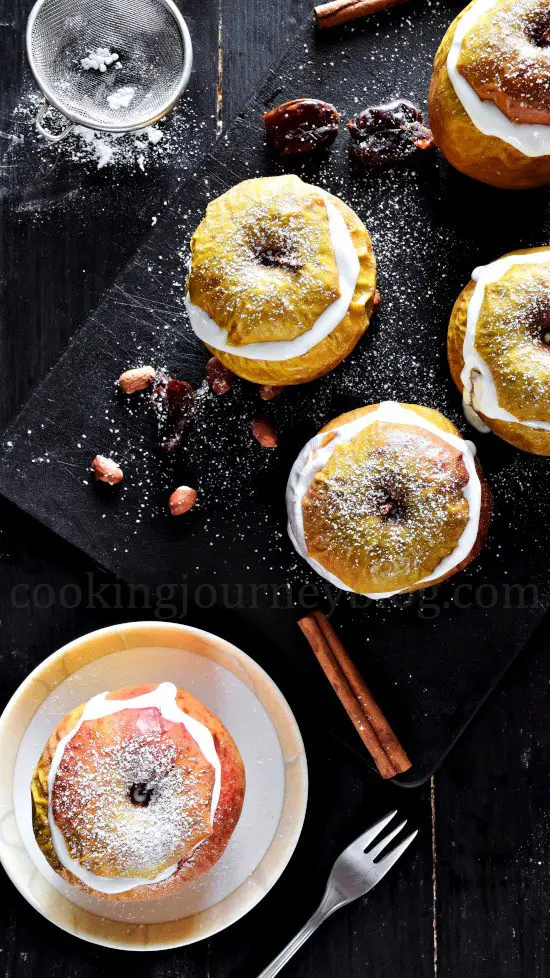Easy Baked Apples with Yogurt on a black board with peanuts and cinnamon stick