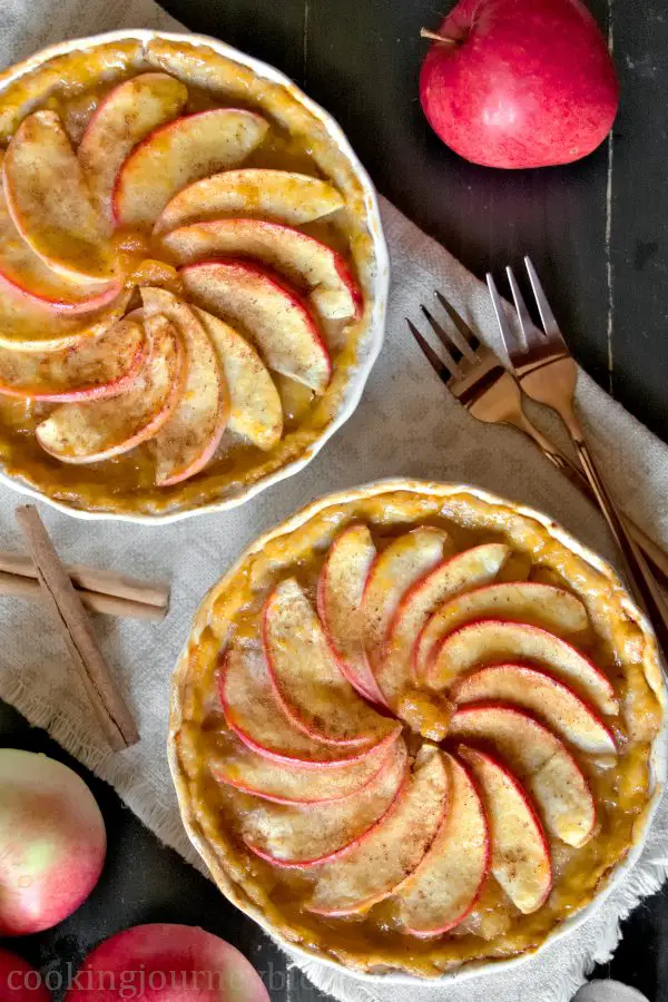 French Apple Tartlets on the taple with cinnamon and forks