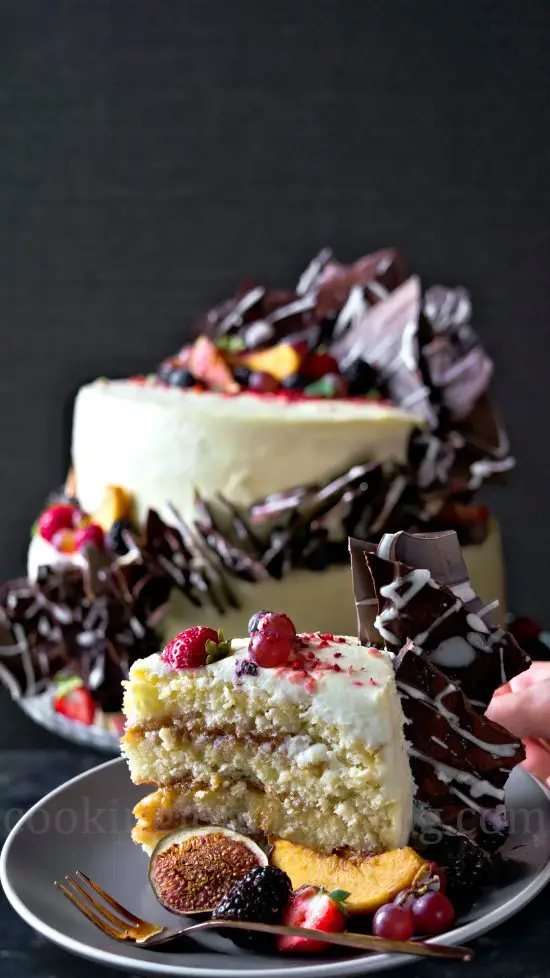 Peace of peach cake with Cream Cheese Frosting, chocolate and fruits. Cake on the background.