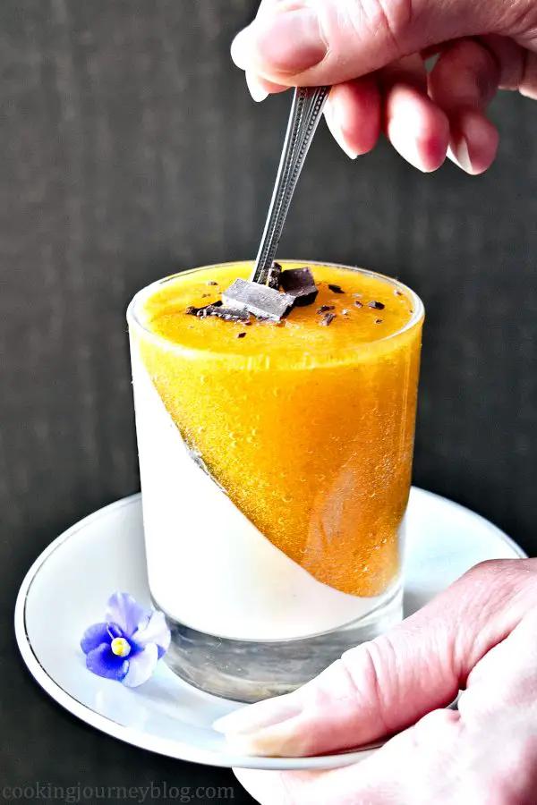 A teaspoon in persimmon panna cotta, holding in hands