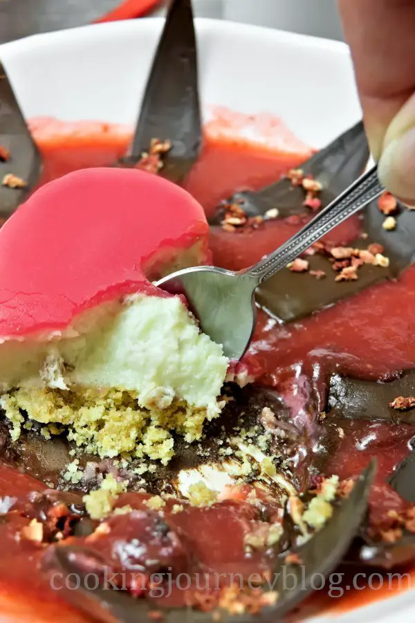 Eating mirror glaze cake with a spoon. Valentine 's desserts made with white chocolate mousse.