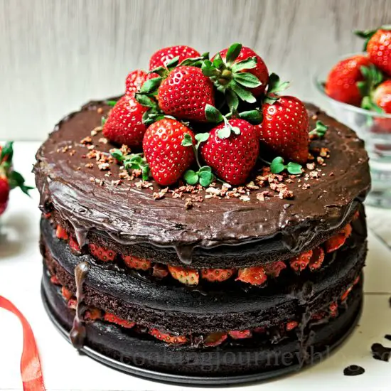 Vegan chocolate cake, decorated with fresh and dry strawberries
