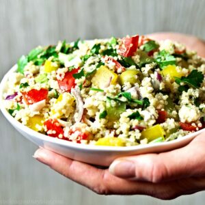 Holding Mediterranean quinoa salad bowl