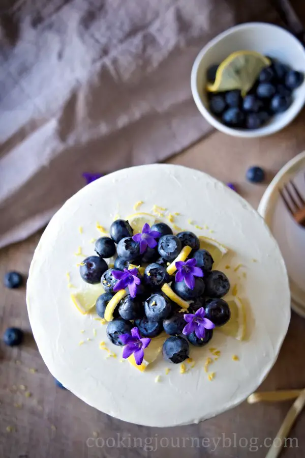 Cake, decorated with lemon slices, blueberries and flowers, view from top