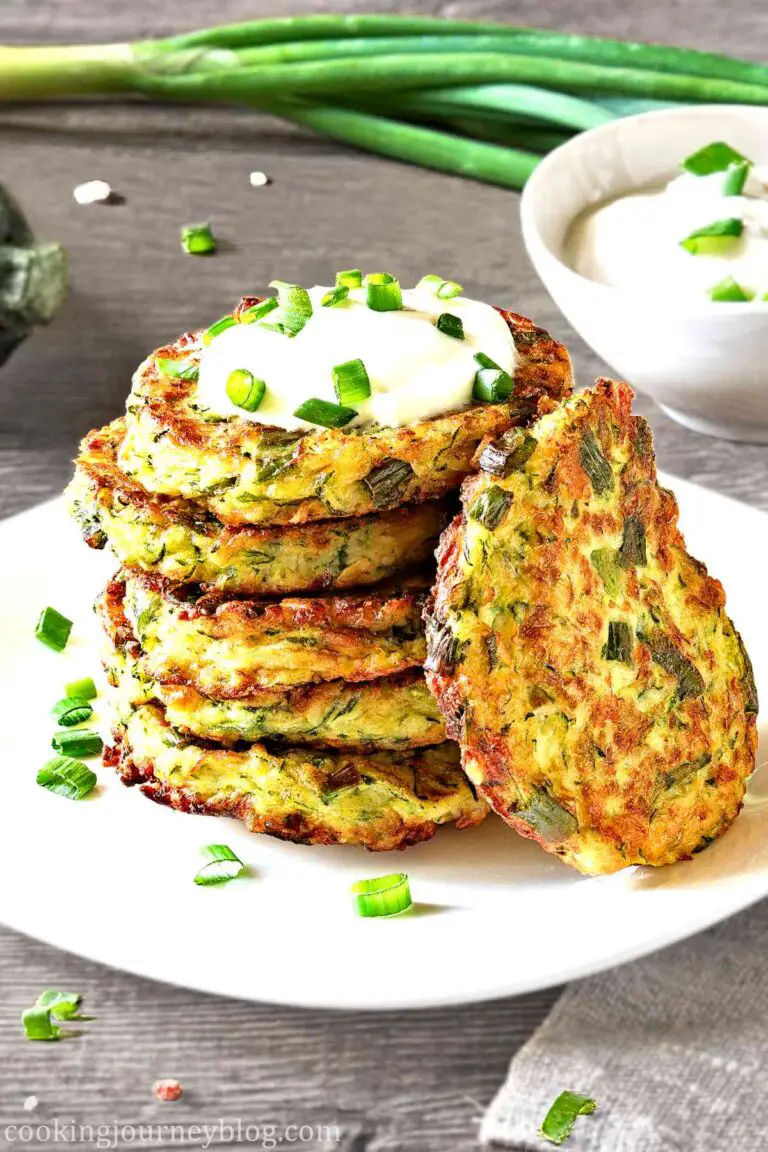 Easy Zucchini Fritters, served on a white plate with Greek yogurt and scallions