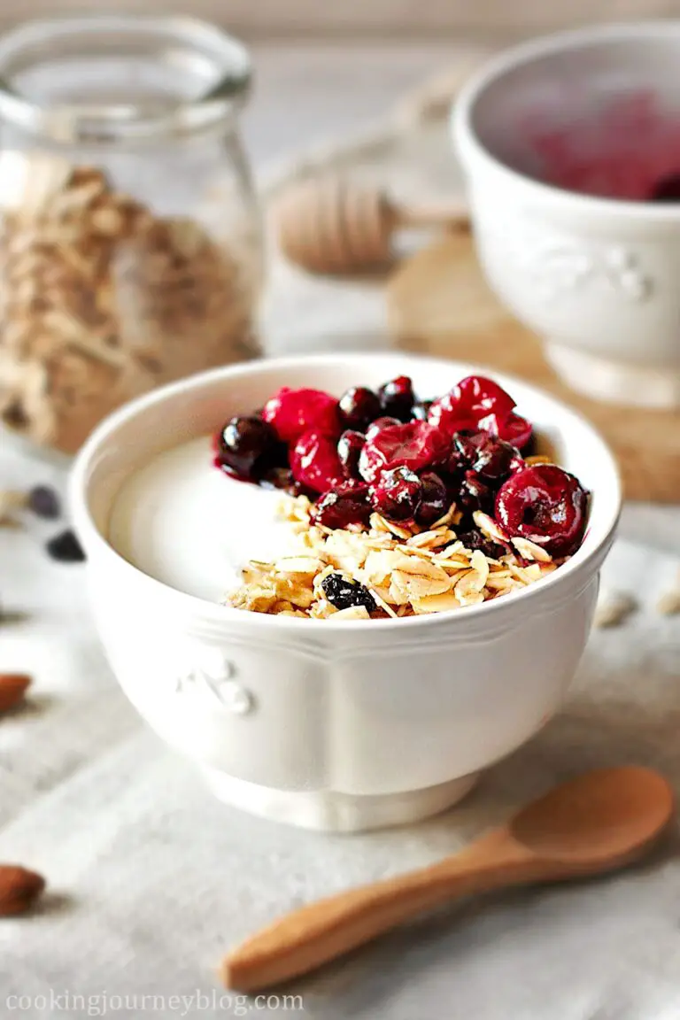 Homemade Granola served with yogurt and berries in a white bowl