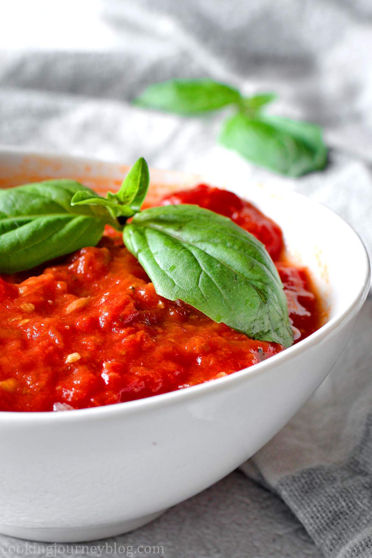 Homemade Marinara Sauce served with fresh basil in a white plate