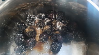 Blackberries, sugar and corn meal in a pan