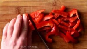 Cut red bell peppers lengthwise, then cut in half and add to the bowl.