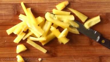 Cut yellow bell peppers lengthwise, then cut in half and add to the bowl.