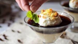 Add a spoon of whipped cream to each panna cotta, sprinkle praline on top and decorate with mint leaves.