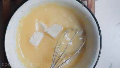 Remove the bowl from heat and start adding butter cubes one by one, mixing with a spoon.