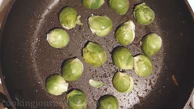Return a pan to the heat and put in Brussels sprouts cut side down. Cook about 2 minutes until Brussels sprouts are slightly browned in the edges.
