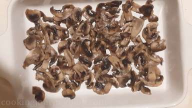 Transfer cooked mushrooms with spices to the oven proof dish and distribute evenly.