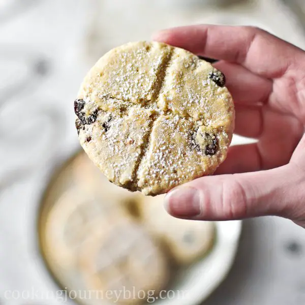 Traditional soul cake recipe, holding a cookie with raisins