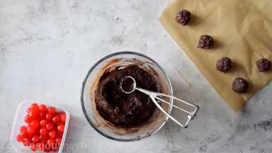 Scoop a ball of chocolate cookie dough on the baking tray, layered with parchment paper. You can form the ball with your hands. If you don't want to be messy, you can dust your hands with cocoa powder or scoop directly to the baking tray. Leave the space between cookies.