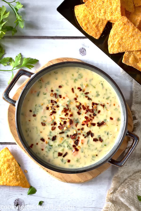 Chile con Queso in a serving bowl with tortilla chips on a side.