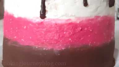 Using an offset spatula, frost the cake from bottom with chocolate, then pink, then leftover white frosting. Frost the top with white frosting, too. Leave the cake to set in the fridge for 2 hours.