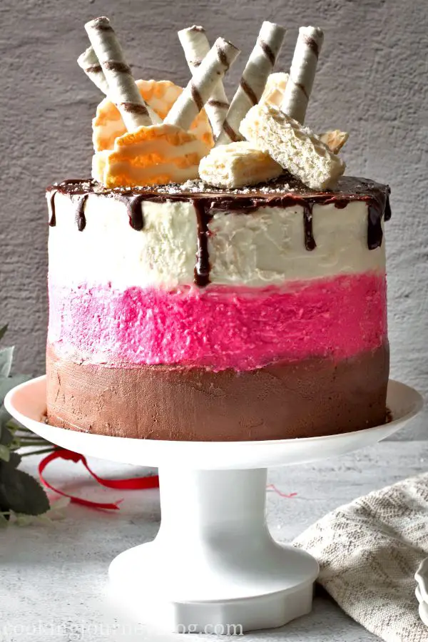 Festive Neapolitan Cake with 3 layers - chocolate, pink and white, decorated with chocolate ganache and wafers
