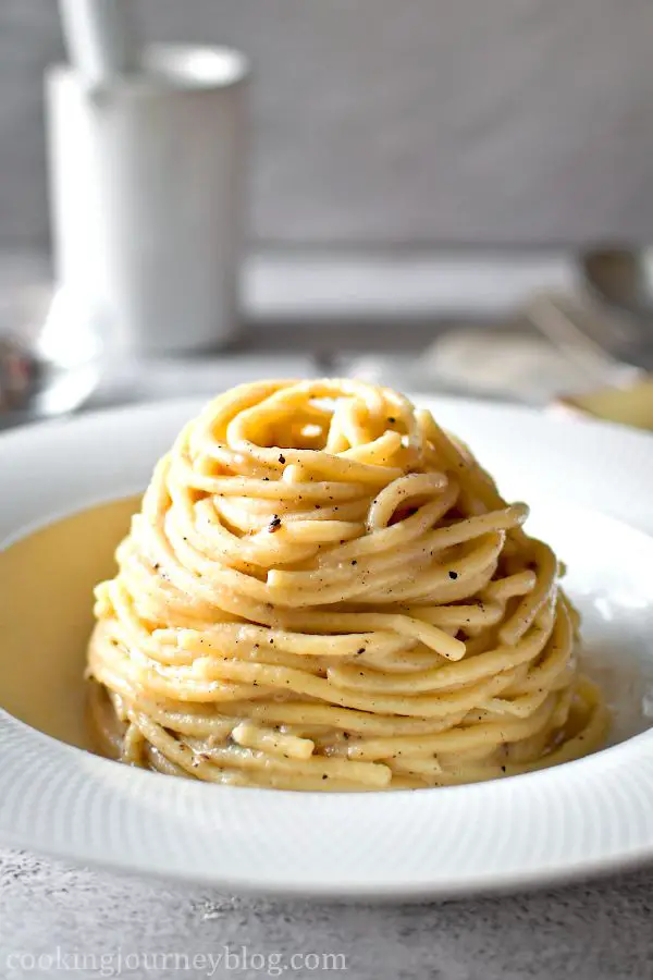 Spaghetti Cacio e Pepe served on the white plate.