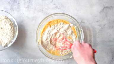 Gradually add dry ingredients to the wet banana mix. Whisk until all incorporated and smooth.
