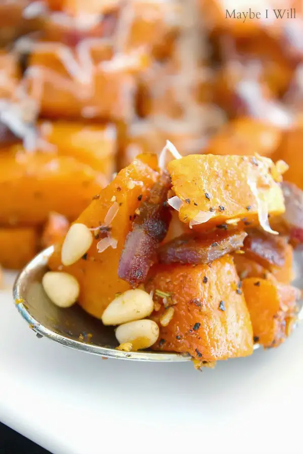 Roasted Butternut Squash pieces with nuts and spices in a spoon