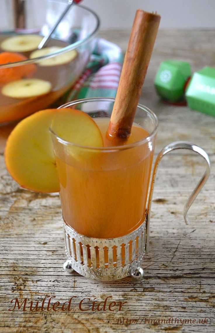 Mulled Cider served in a glass with cinnamon stick and a slice of apple