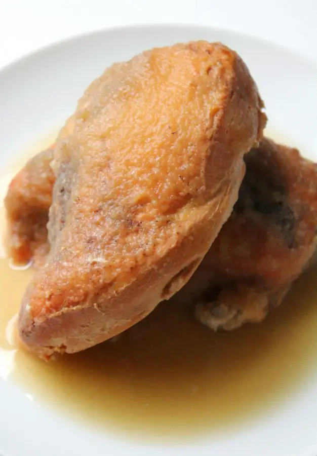 Cooked chicken breasts served on a plate with applesauce