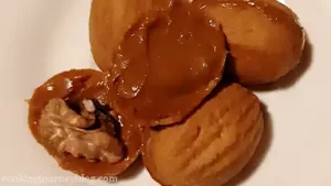 Fill shells with caramelized condensed milk, add a half of walnut in the middle. Close cookies, gently pressing together. Use your fingers to wipe around the center excess condensed milk.