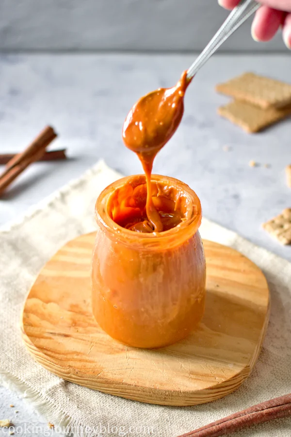 Spoon with cajeta Mexican Caramel sauce in a jar