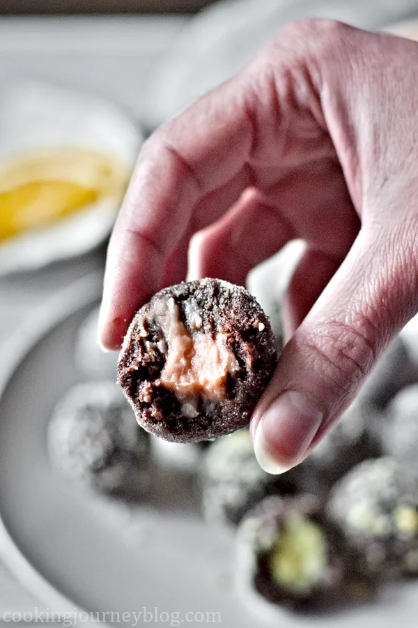 Holding keto truffle with grapefruit filling in hands