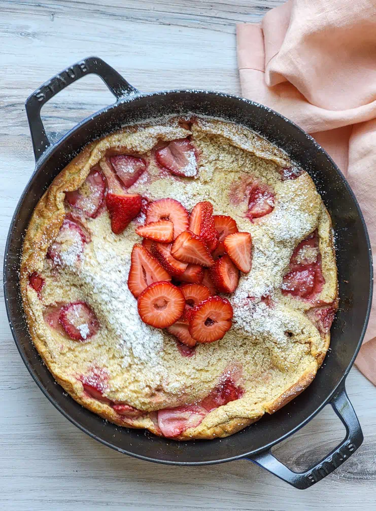Dutch pancake in a pan, topped with strawberries