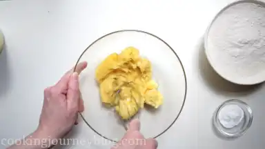 Mash bananas in a large bowl.