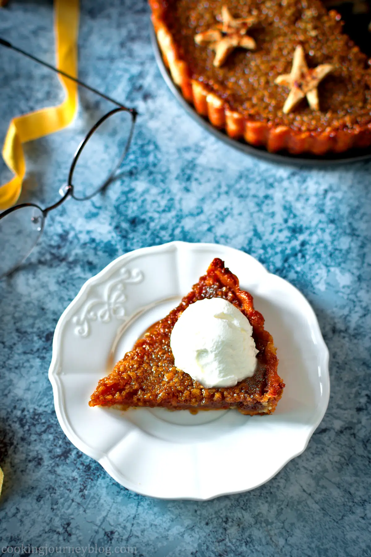 A slice of Harry Potter treacle tart served on a white plate with a dollop of yogurt