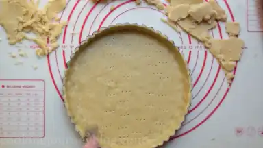 Using the fork, prick the holes in the bottom of the tart.