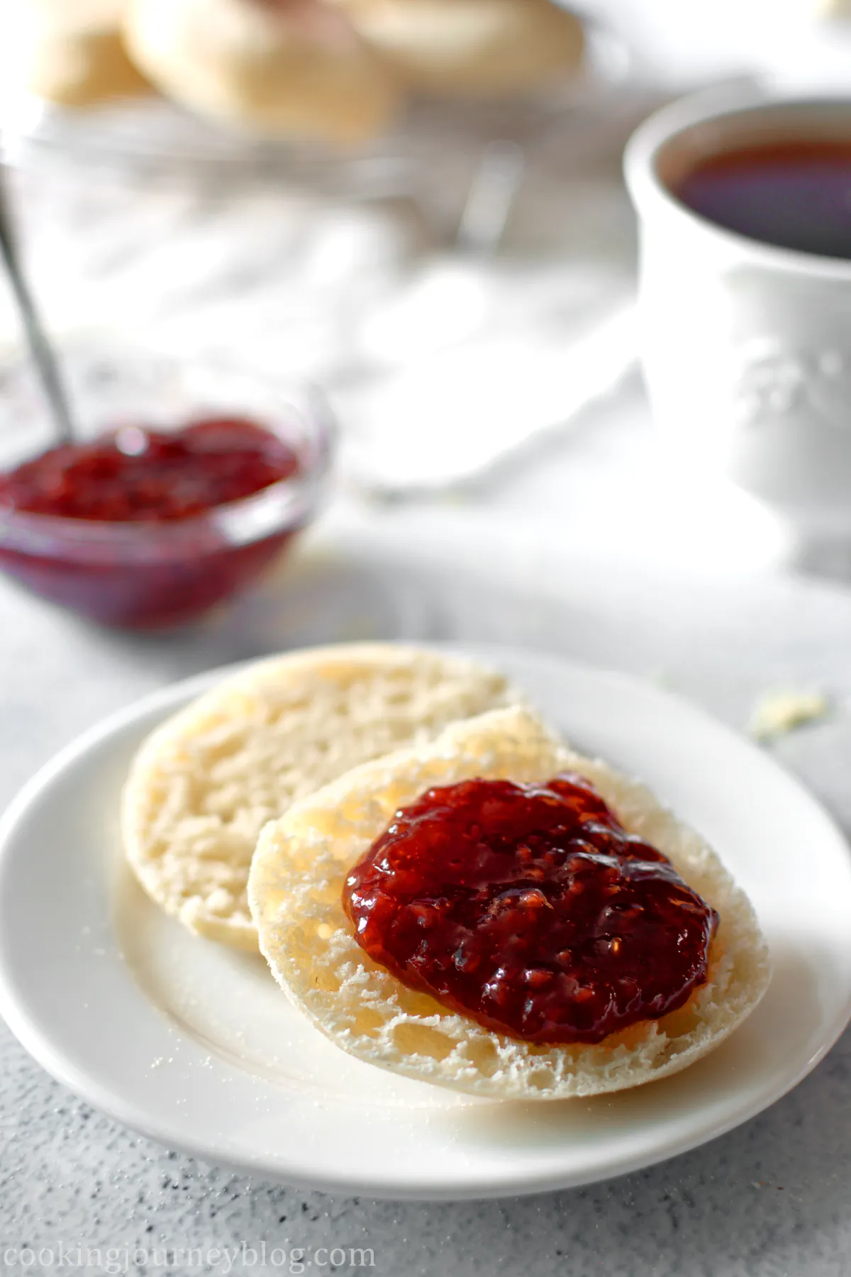 Vegan English muffins, cut in half and served with strawberry jam on top