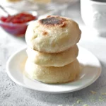 3 Vegan English muffins served with jam on a white plate