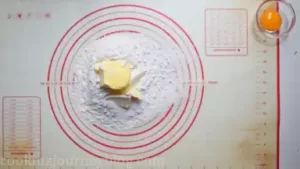 Start pressing butter into the flour and sugar.
