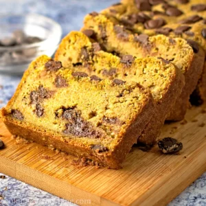 Pumpkin chocolate chip bread sliced on a wooden board